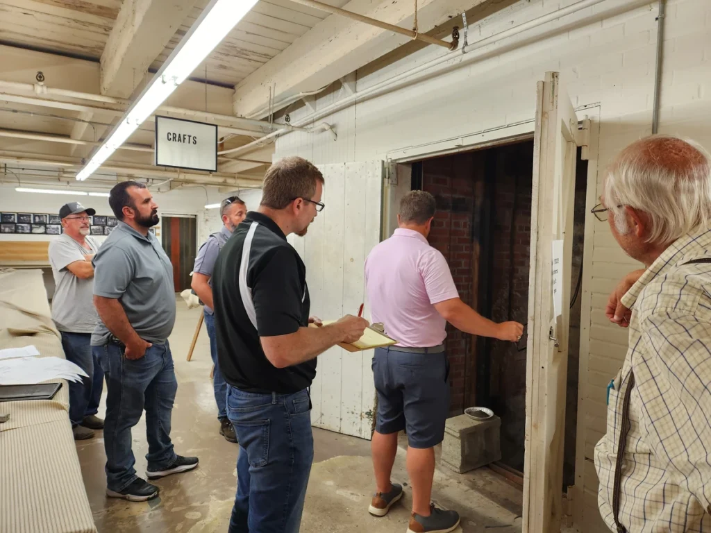 Group of individuals taking measurements and planning for the elevator project.