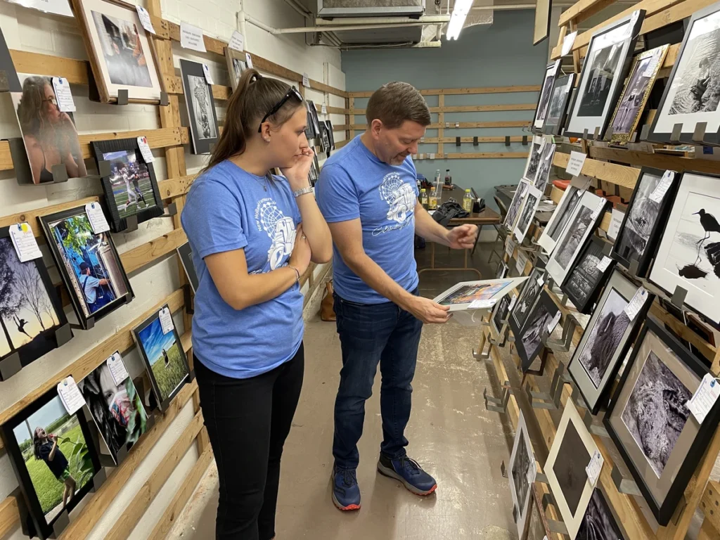 Volunteers arrange the photography exhibits for the 2022 fair.